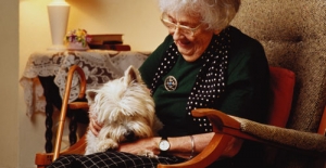 An elderly lady with her dog at home