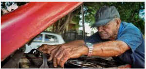 Elderly man mechanic working on his vehicle